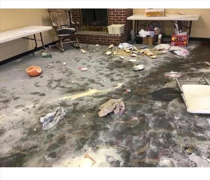 A vandalized room with broken items all over the ground