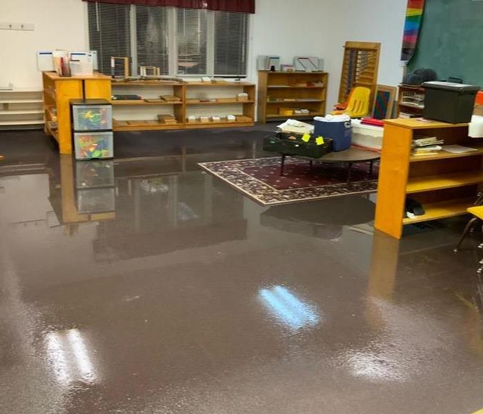 Photo of a classroom that has standing water on the floor.