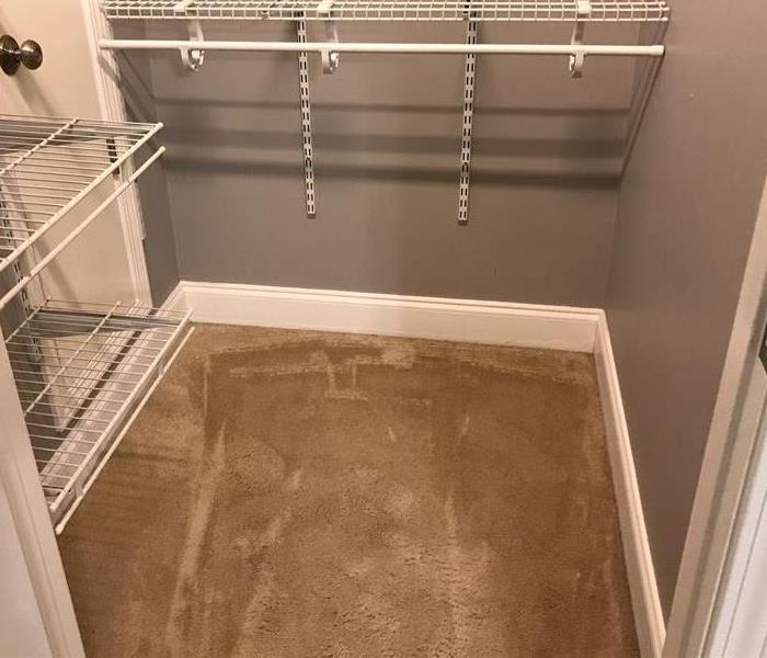 Closet with saturated carpet from leaking pipe