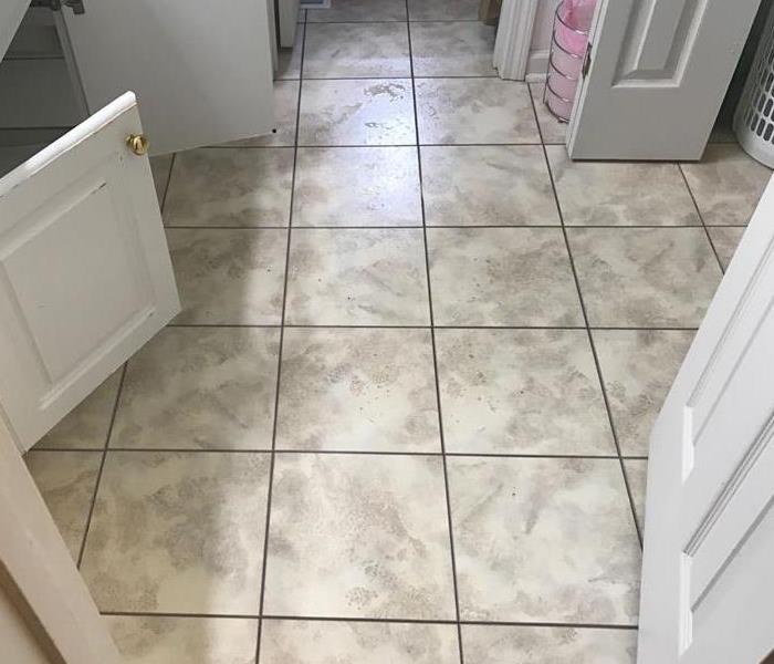 Bathroom floor with water damage from broken pipe