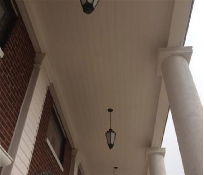 A picture of the outside porch ceiling and columns painted white