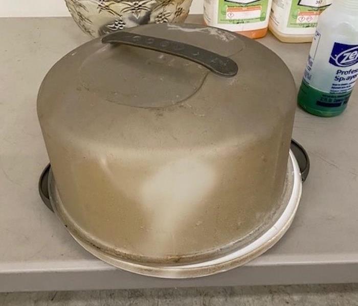 A cake pan that is black and extremely dirty.