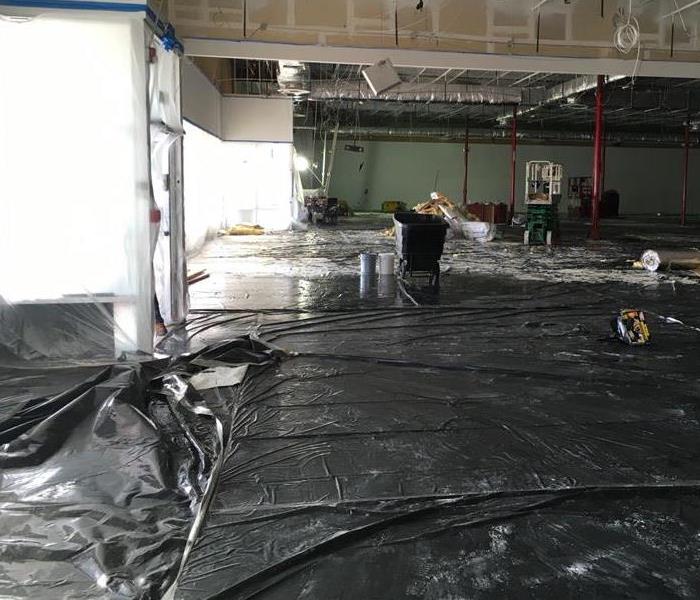 Warehouse space with black tarp on floor that has been flooded due to failed sprinkler system