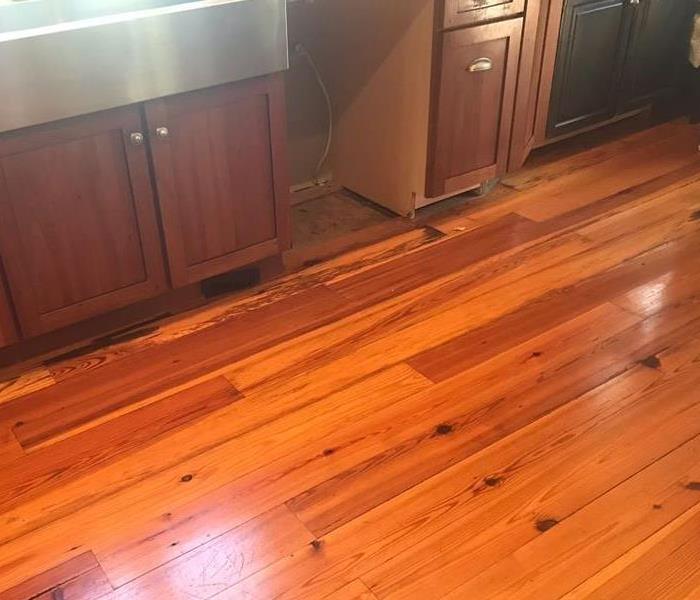 Kitchen in home where dishwasher leak caused damage to hardwood flooring