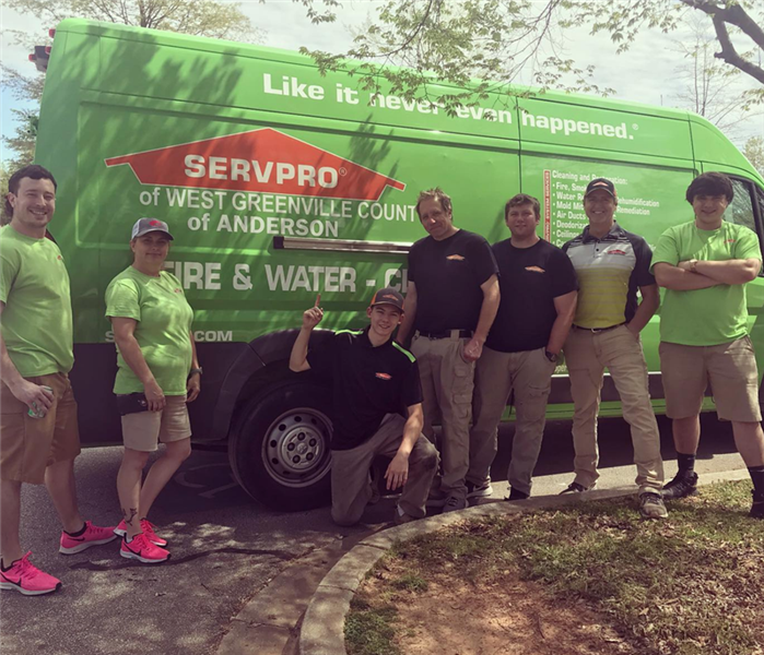 7 individuals wearing SERVPRO gear standing in front of a SERVPRO vehicle