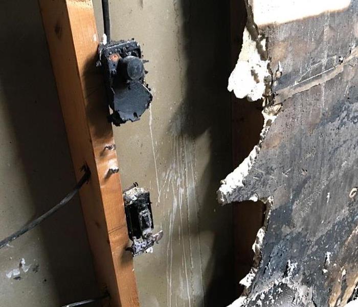 Outlet that is charred from an electric fire in home
