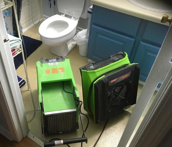 SERVPRO green equipment in bathroom drying wet material
